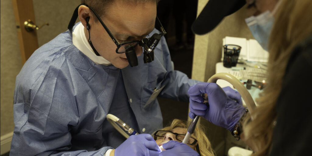 Dentist performing dental procedure on patient. Dentist performing dental procedure on patient.