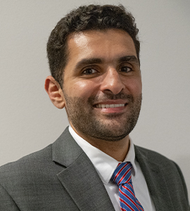 Here's an alt tag for the image: Headshot of a man in a suit.